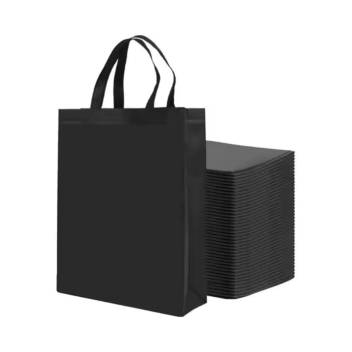 Schwarze Non-Woven Tragetasche mit Griffen und großem Taschenstapel – ideal für Promotions & Verpackung.