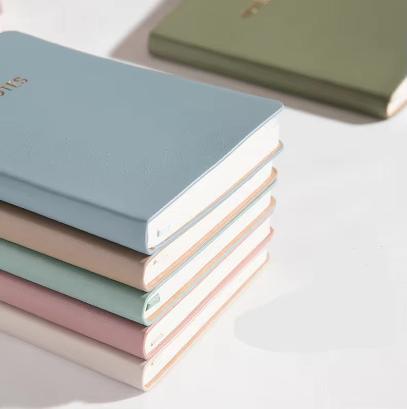 Stapel hochwertiger Pastell-Notizbücher mit cleanem Hardcover – ideal für Branding & Firmengeschenke.