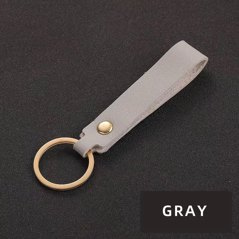 Grauer-Schlüsselanhänger mit goldenem Ring – minimalistisches Design, ideal für Logo-Branding.